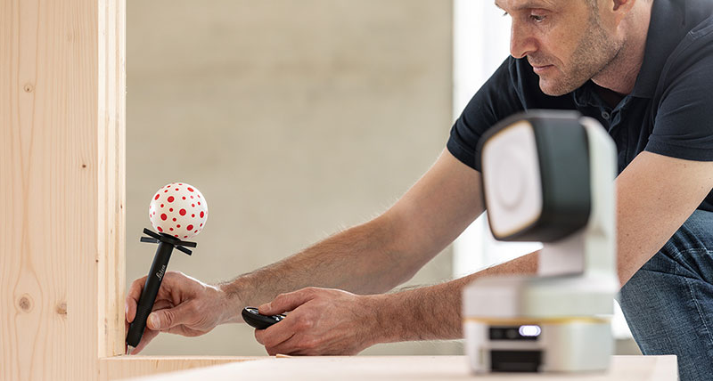Worker using the Leica iCON vPEN to precisely measure a corner.
